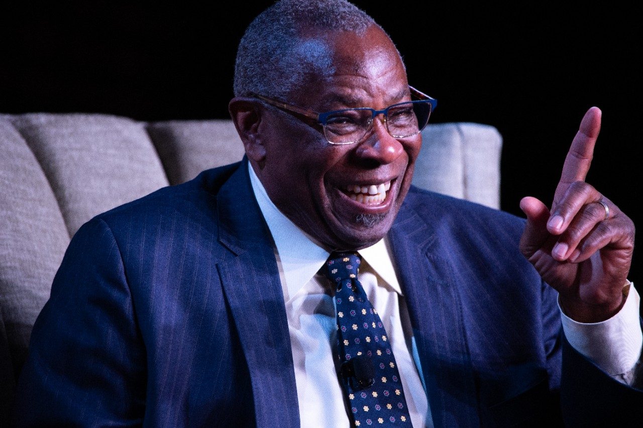 Close up of Dusty smiling and pointing his finger as he  recounts a fond memory.