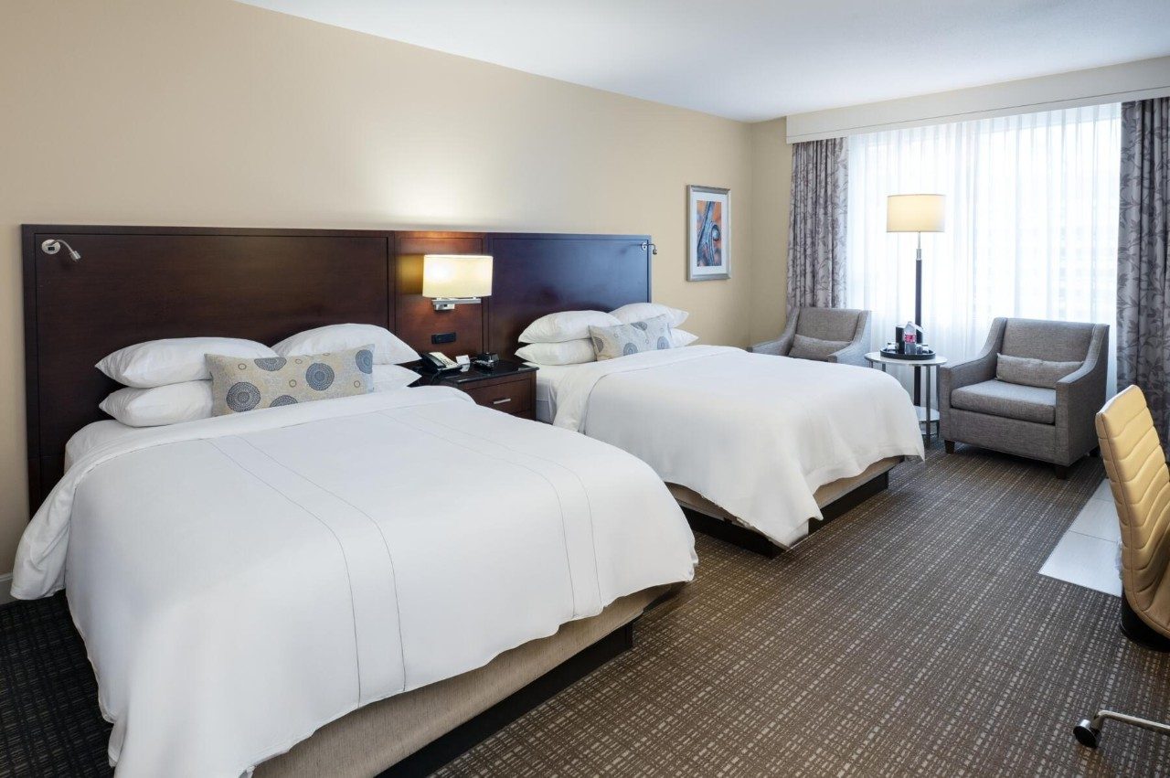 Sleeping area in room with two queen beds and a kitchenette