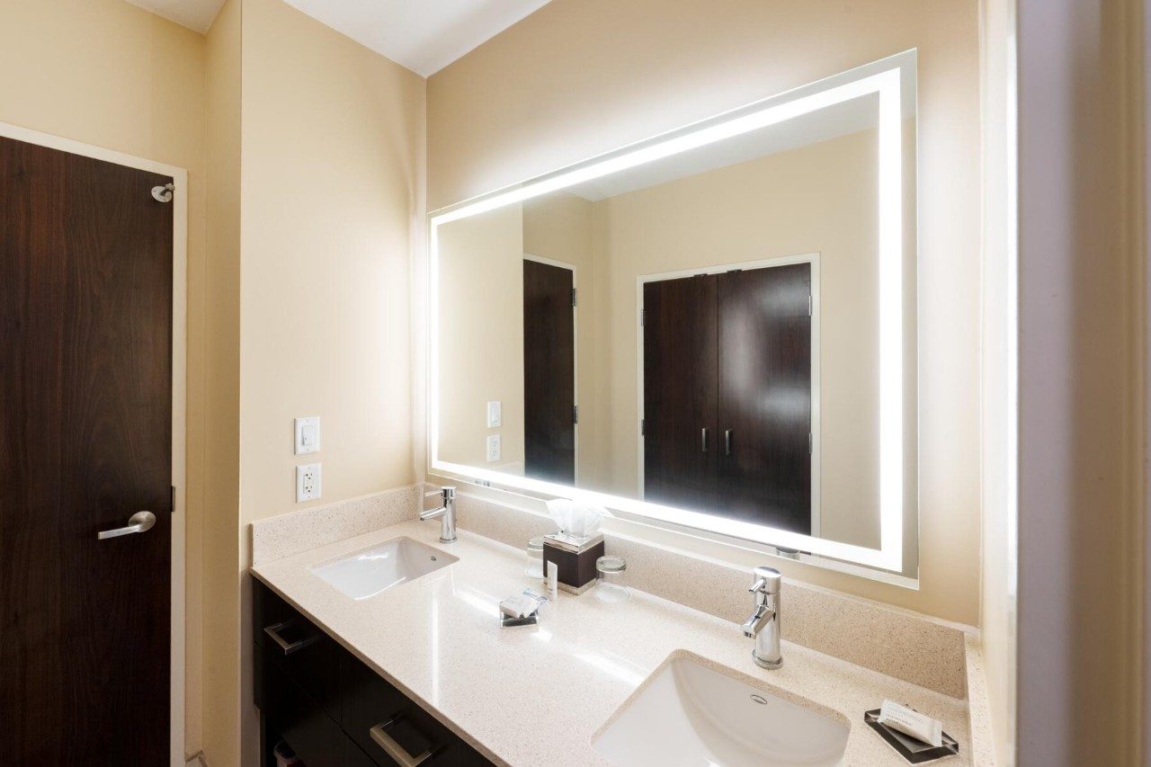 Bathroom sink and mirror in a suite with king bed and kitchenette