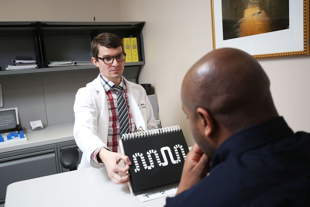 Kyle Knoll, M.D., conducts a neuro-assesment test with a patient