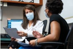 Dr. Pamela Soliman speaking with a staff member in clinic