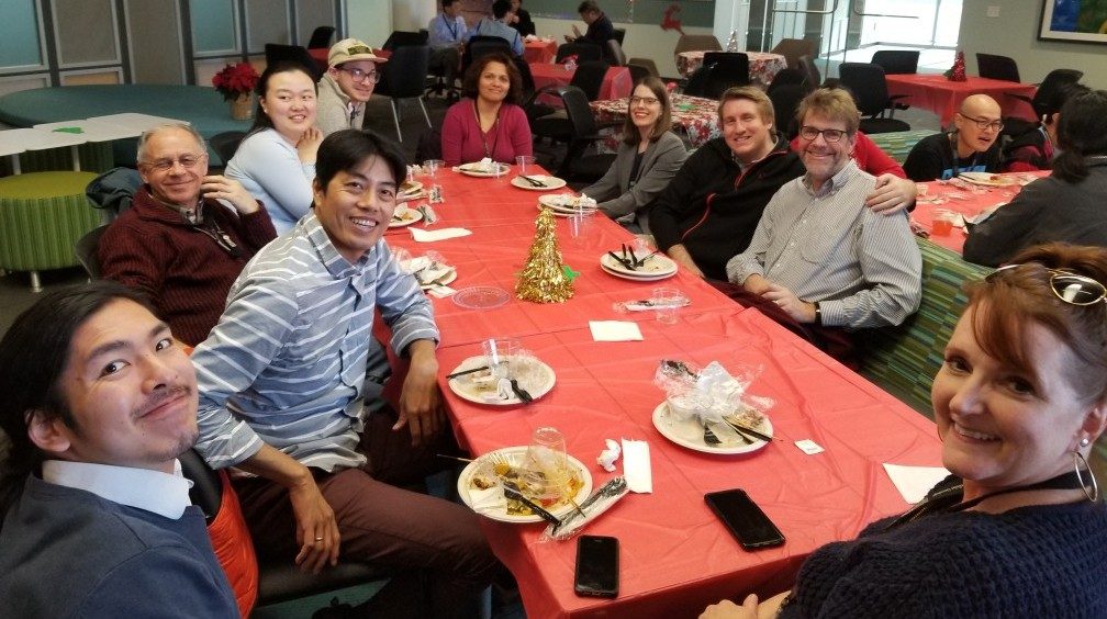 Ten people sit around a table