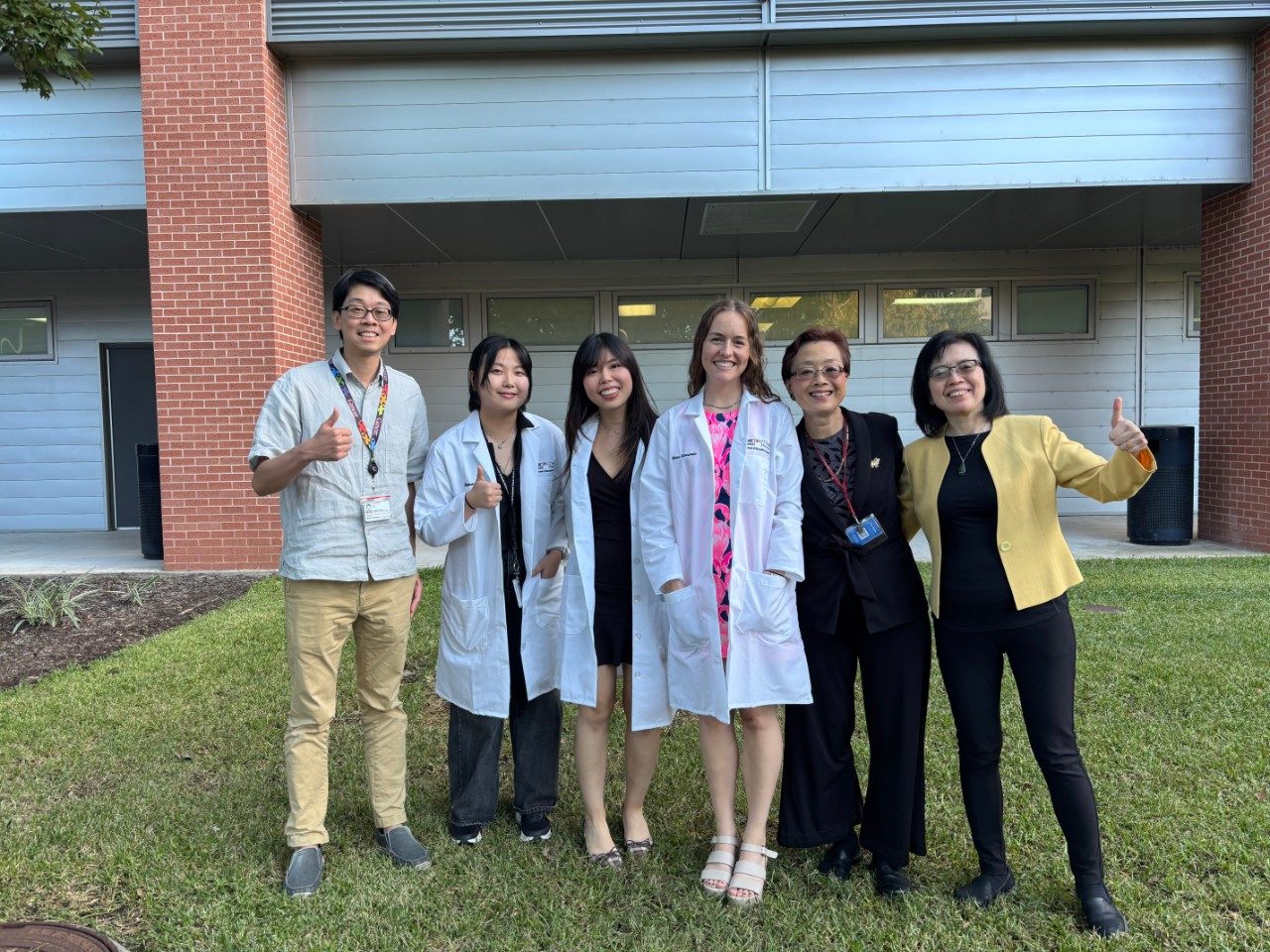 Six people pose outside