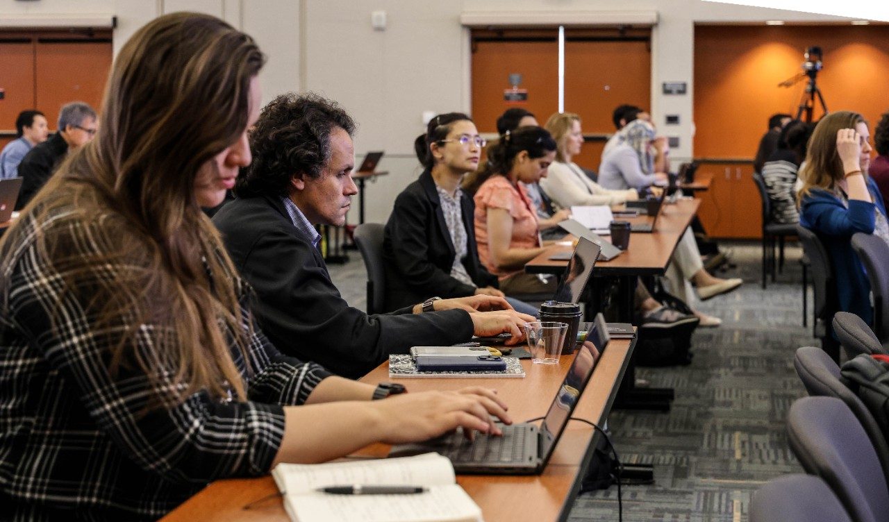People sitting at tables with laptops open