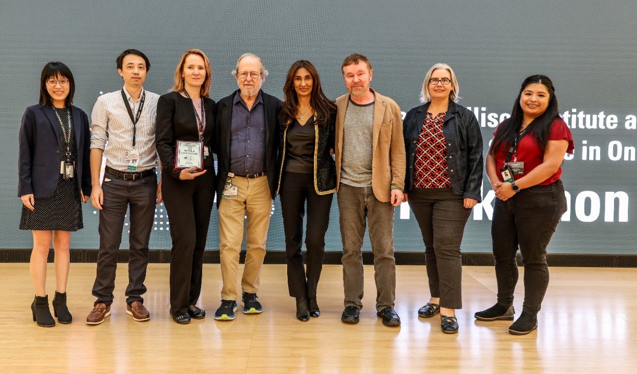 Eight people pose in a line