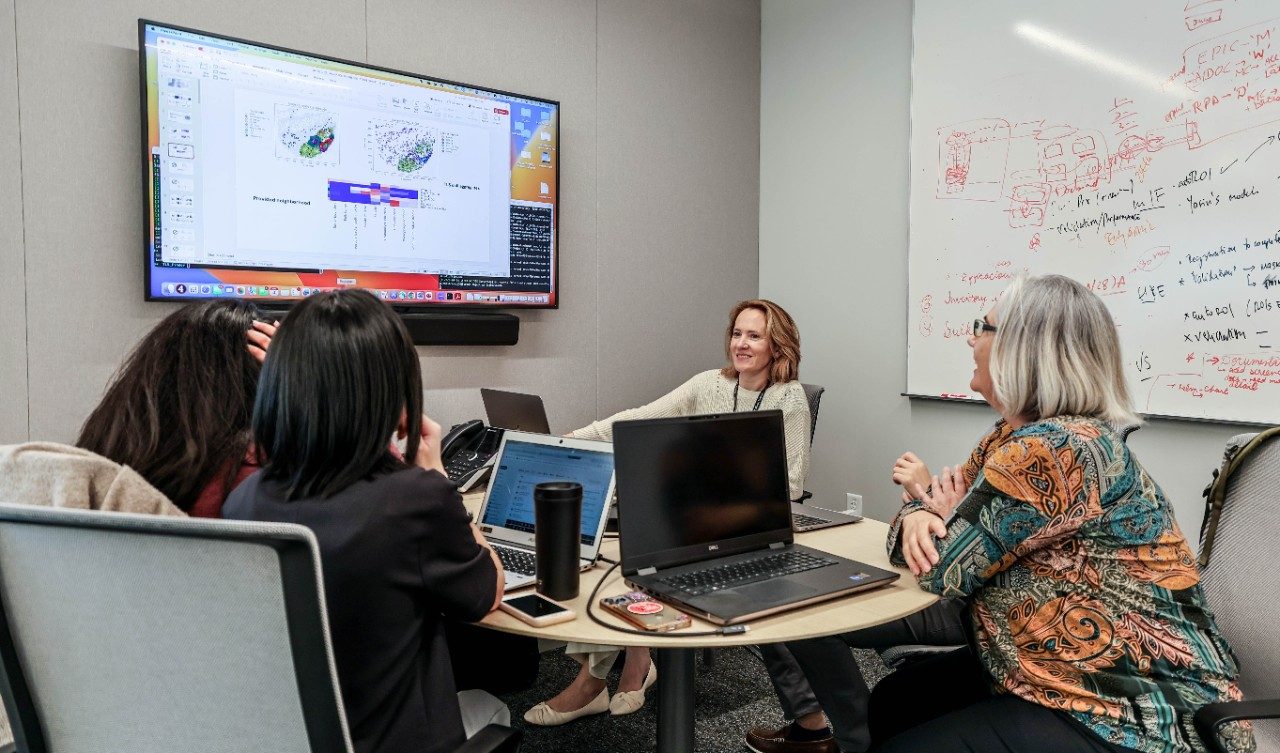 Four people sit around a table an appear to be working
