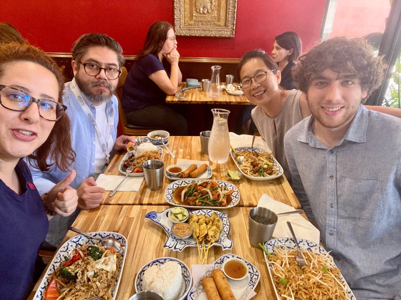 Four people gathered around a restaurant table with lots of food on it