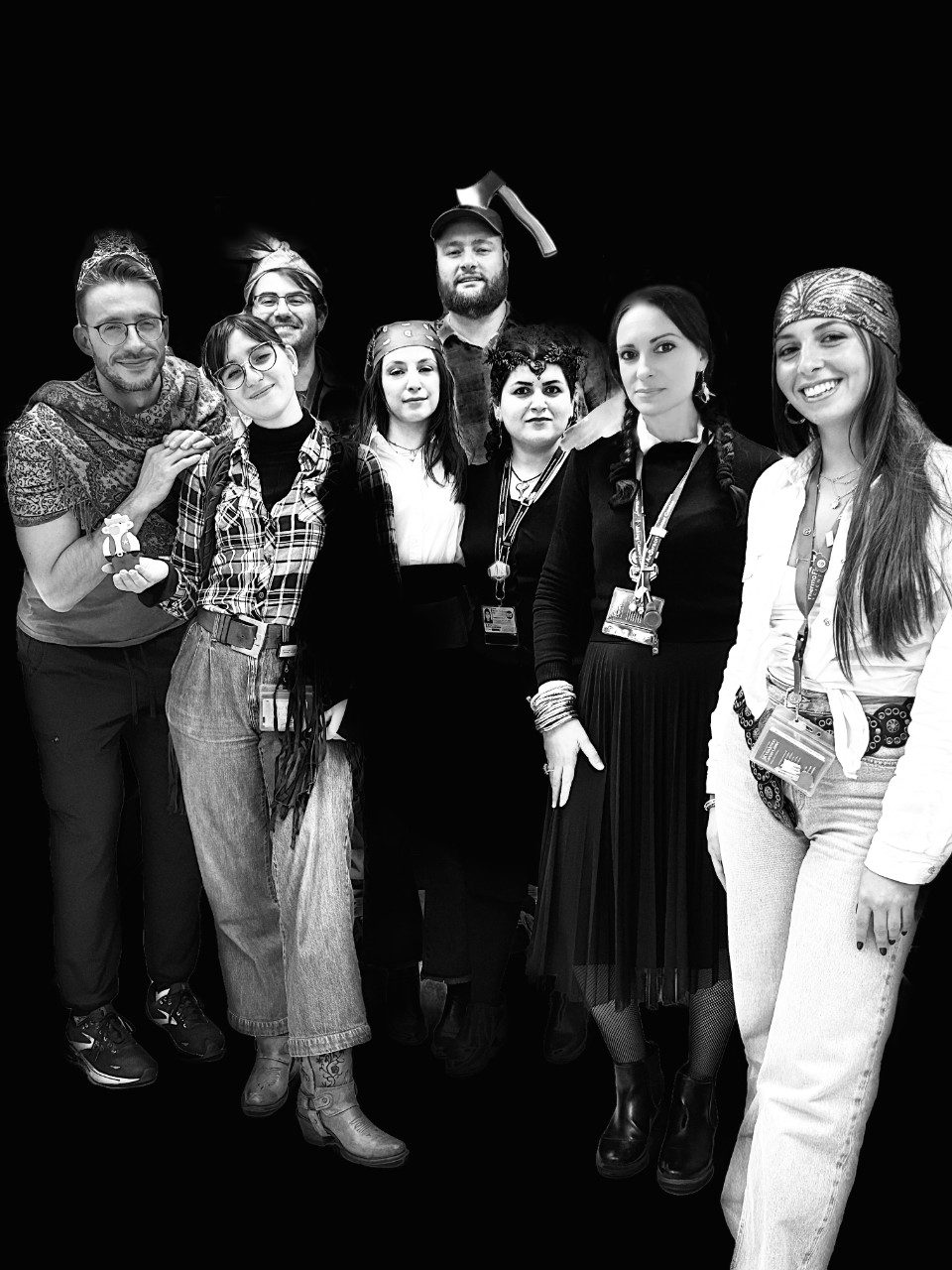 Seven people pose in Halloween costumes in a black and white photo