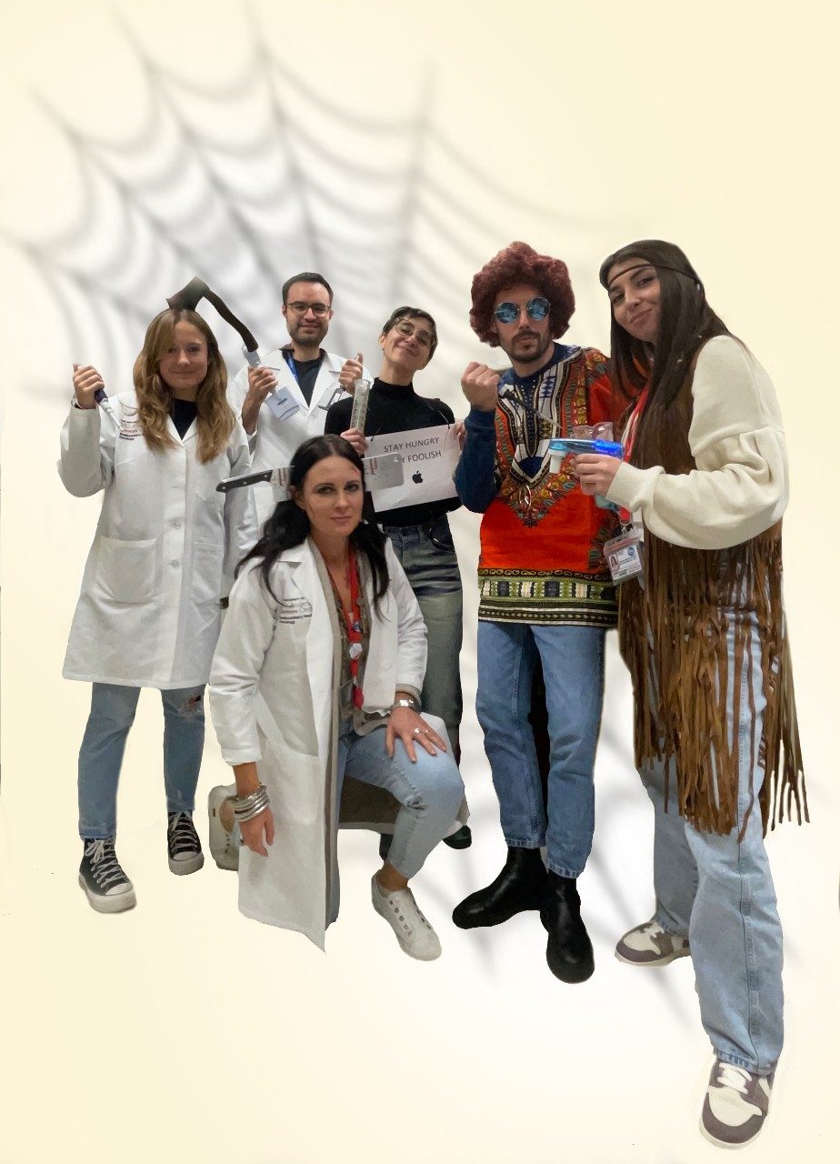 6 lab members in costumes in front of a spider web