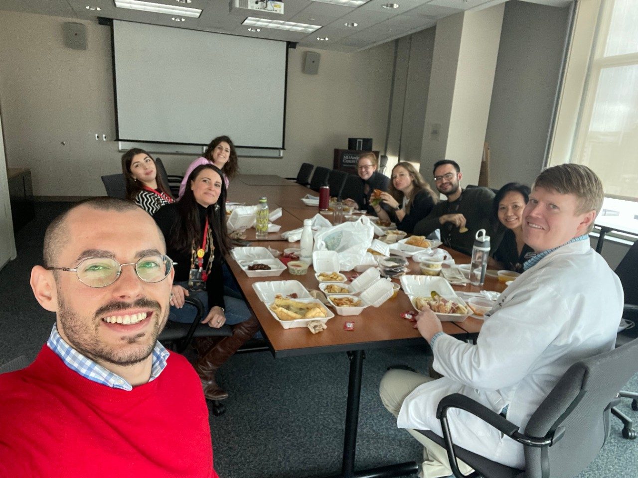 Selfie of lab group members around a conference room table