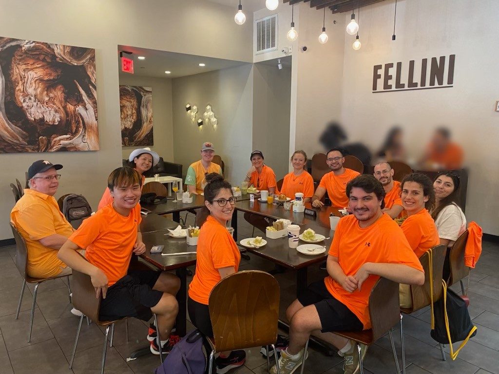 The team spread between several tables at Fellini restaurant in matching neon orange t-shirts