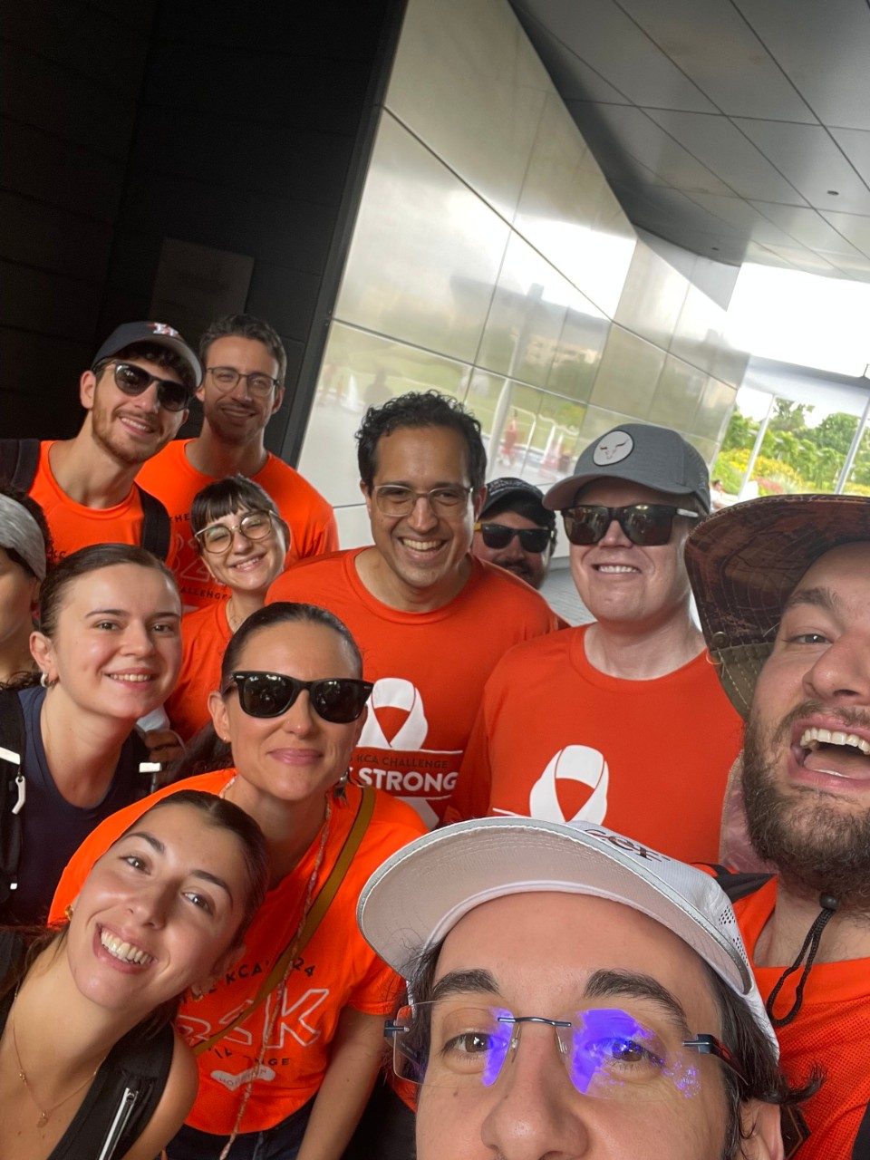 Selfie of group of people in neon orange shirts