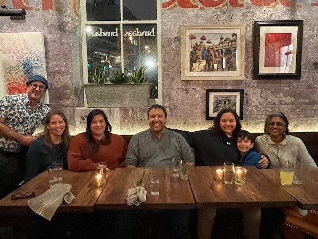 7 students and alums eating dinner at a restaurant table