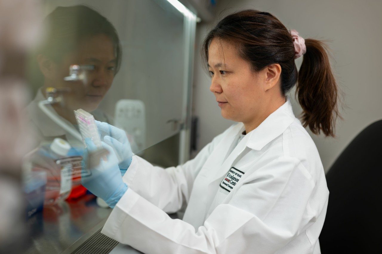 Eschweiler lab member in white coat performing experiment