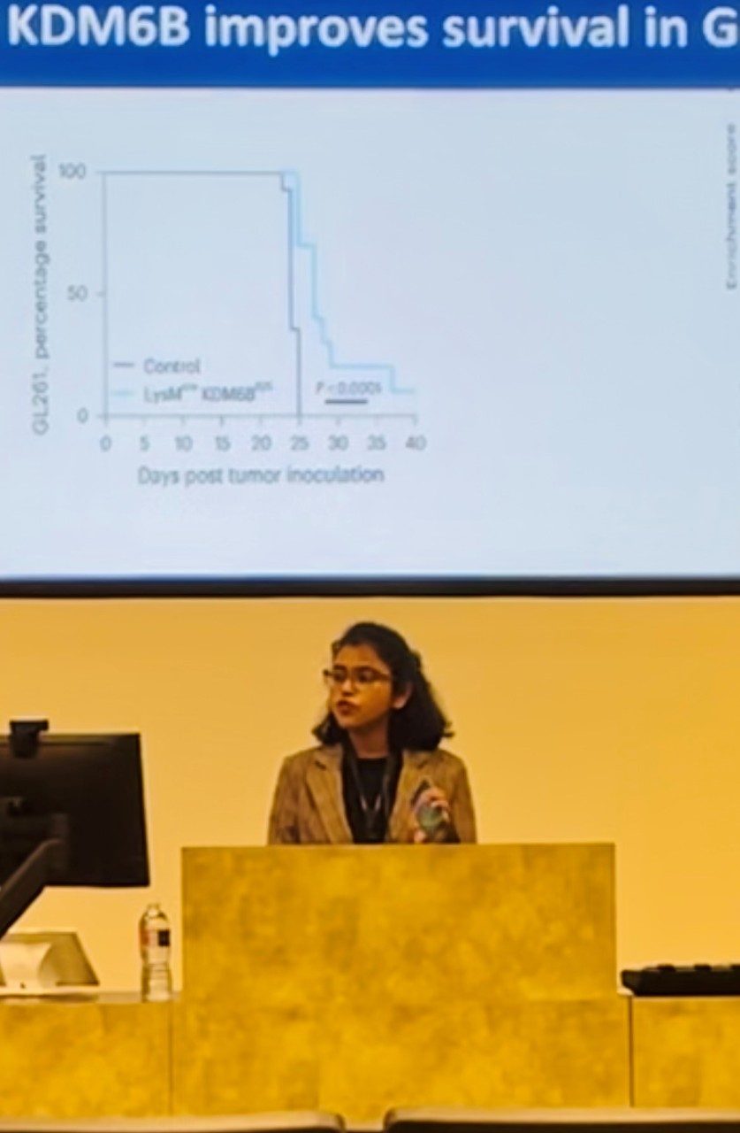 Zoomed in picture of lab member giving a presentation, with part of a slide visible behind them