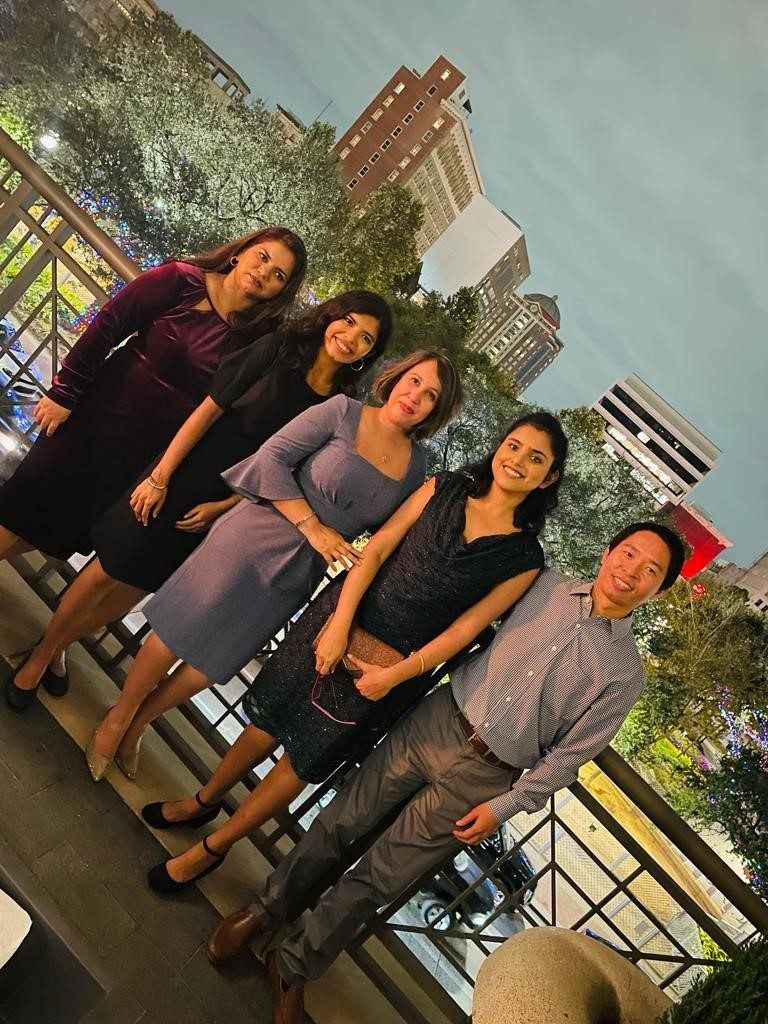 Five lab members pose on a balcony