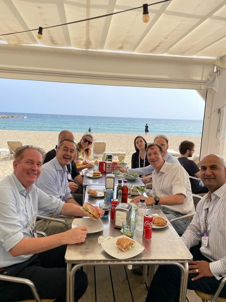 People eating at a table with water in the background