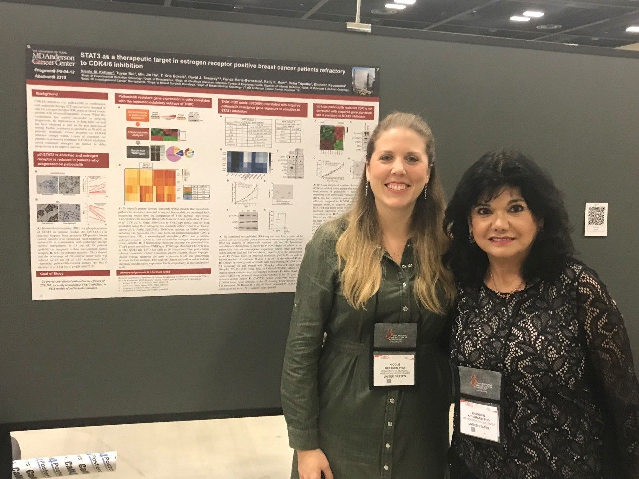 Two people in front of a scientific poster 