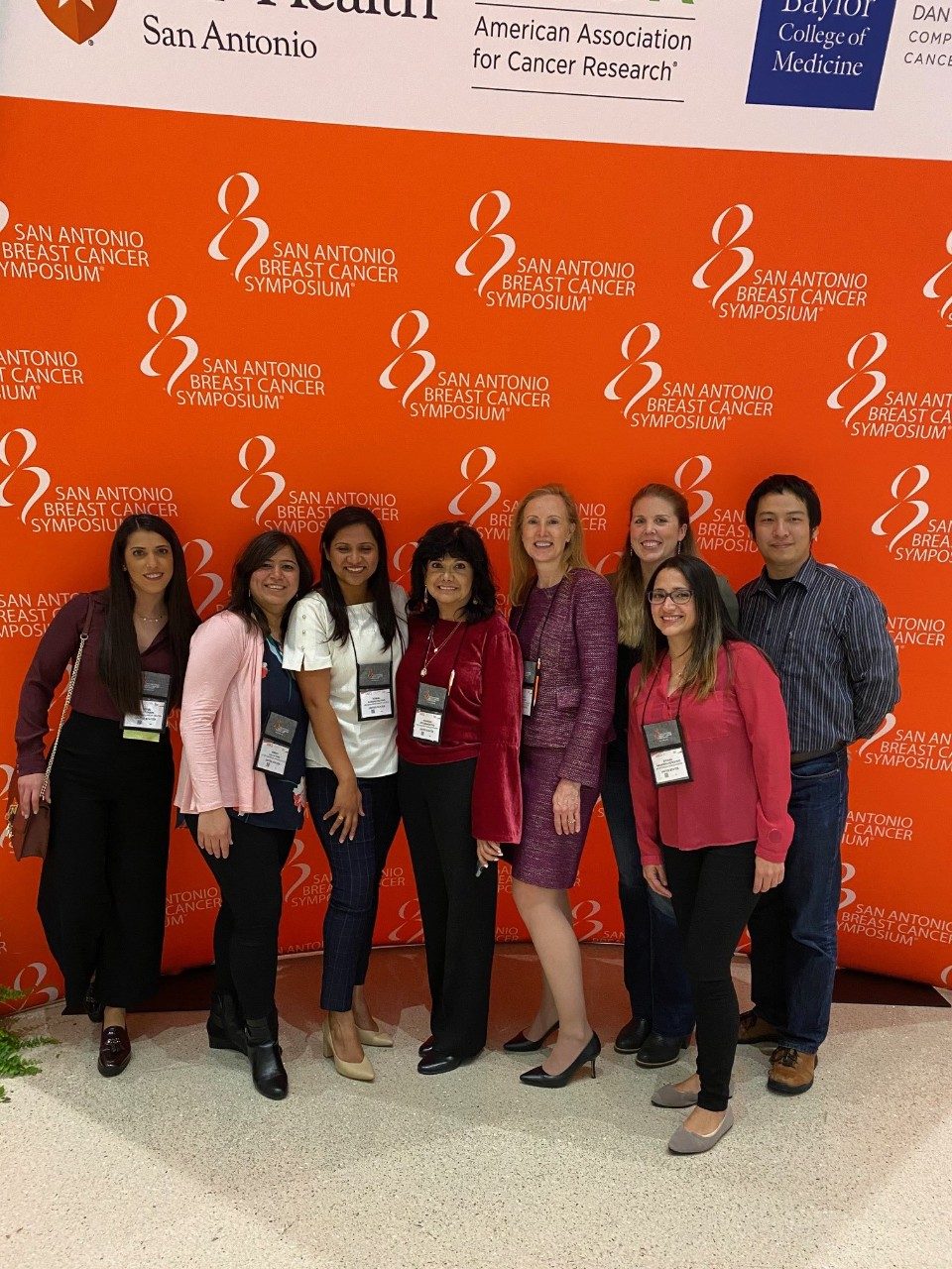 Eight people in front of a branded backdrop