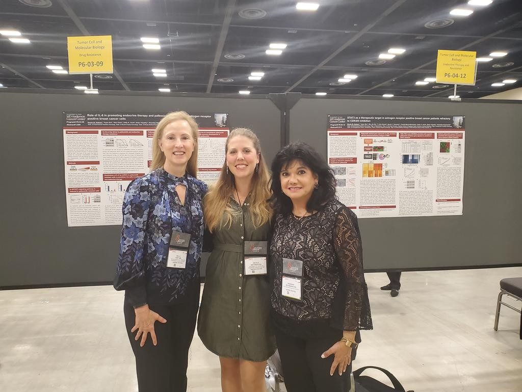 Three people in front of a scientific poster 