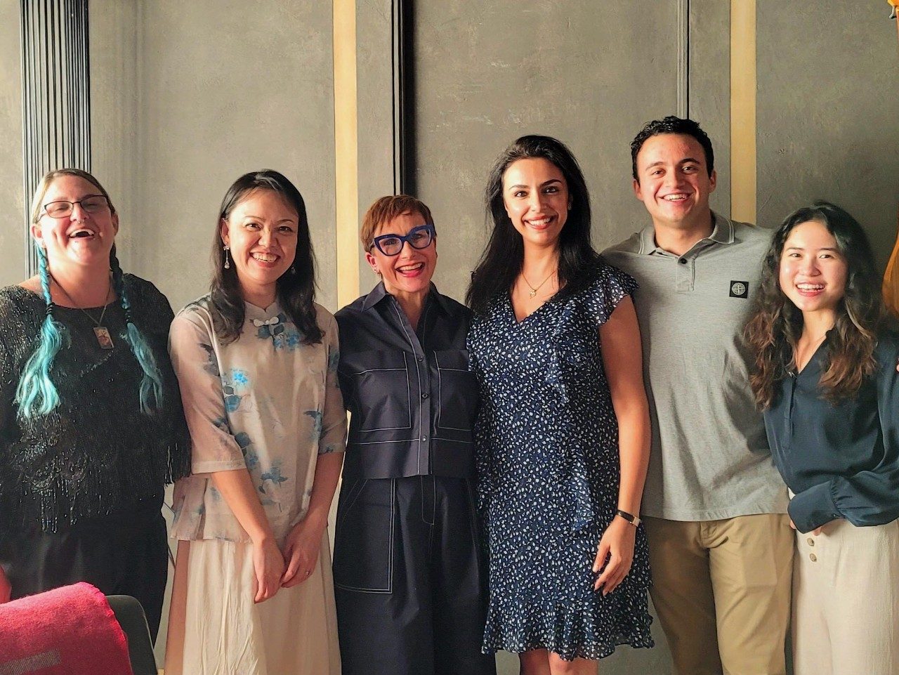 Six people stand in a line posing for the camera