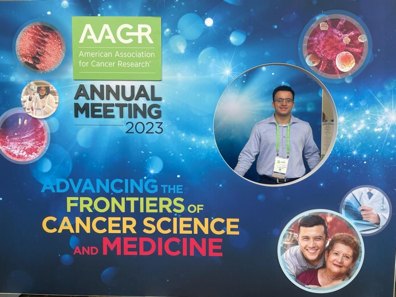 A man poses in a photo backdrop