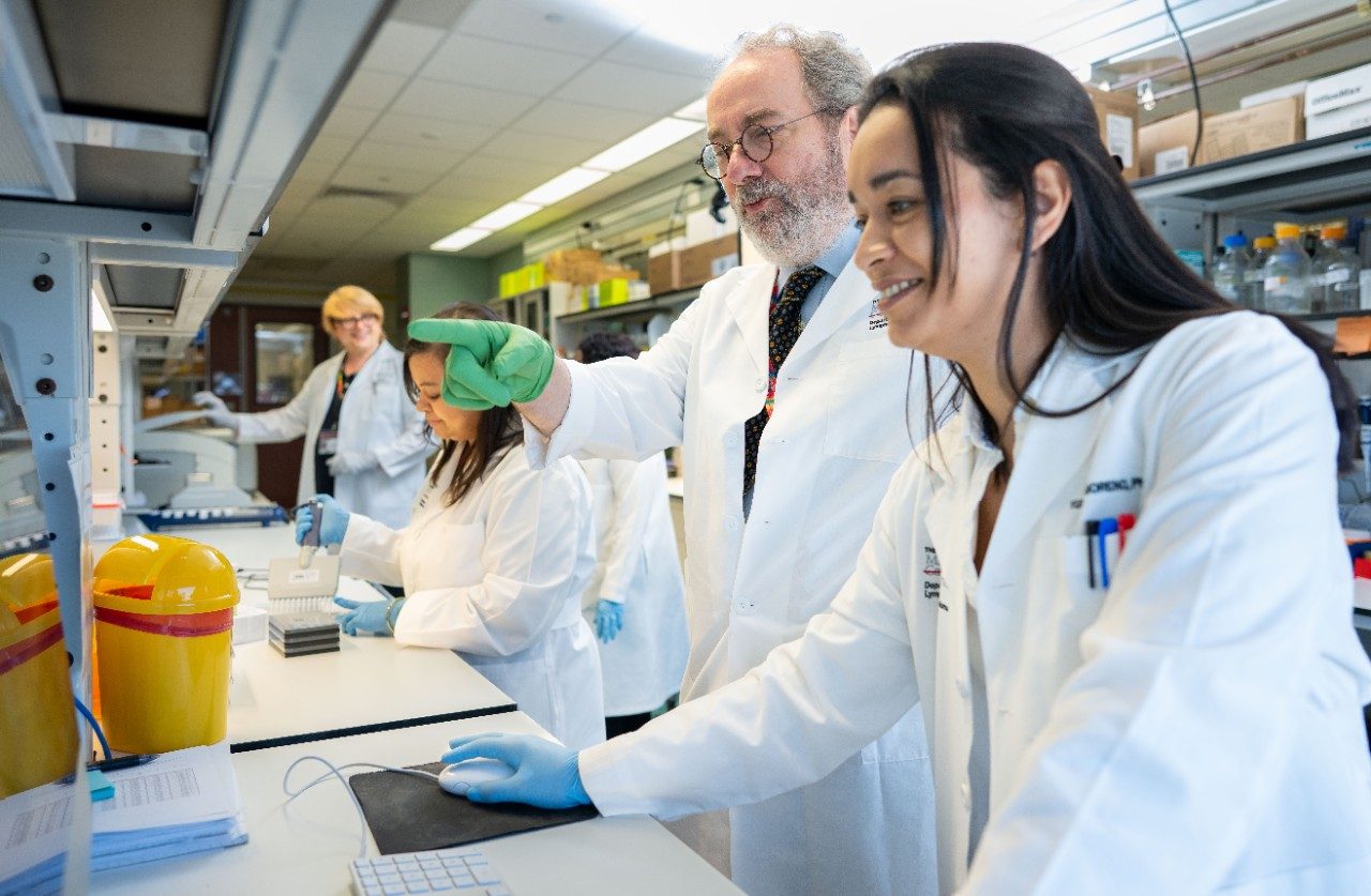 Three people working at a lab bench