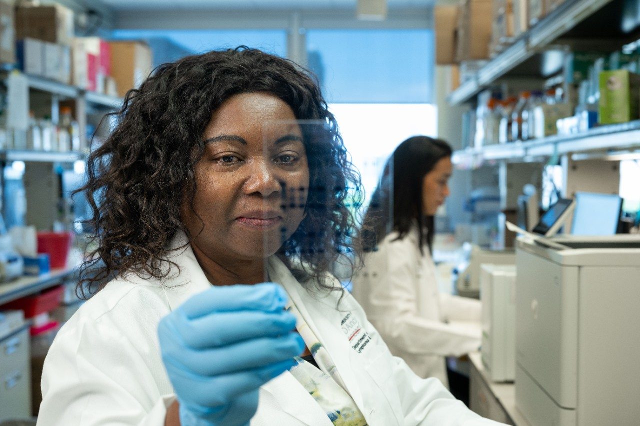 Woman holding up a sample in lab