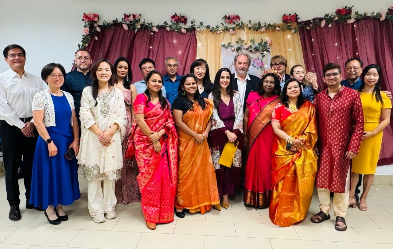 Group of people posed at a wedding, some in saris