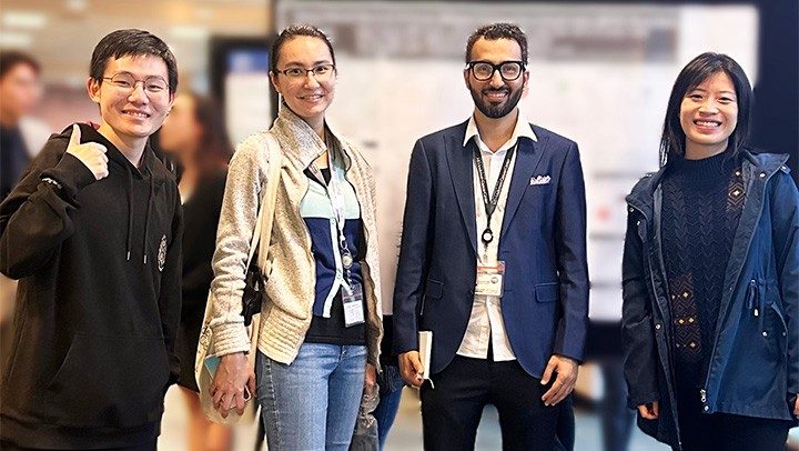 Four people stand in front of a scientific poster session