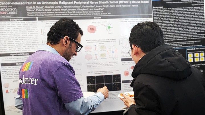 Two men look at a poster