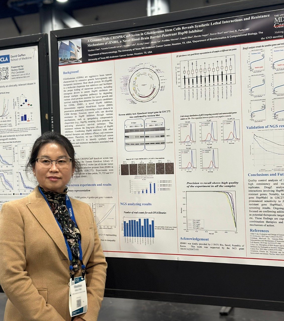 Woman with lanyard around her neck posing next to a poster