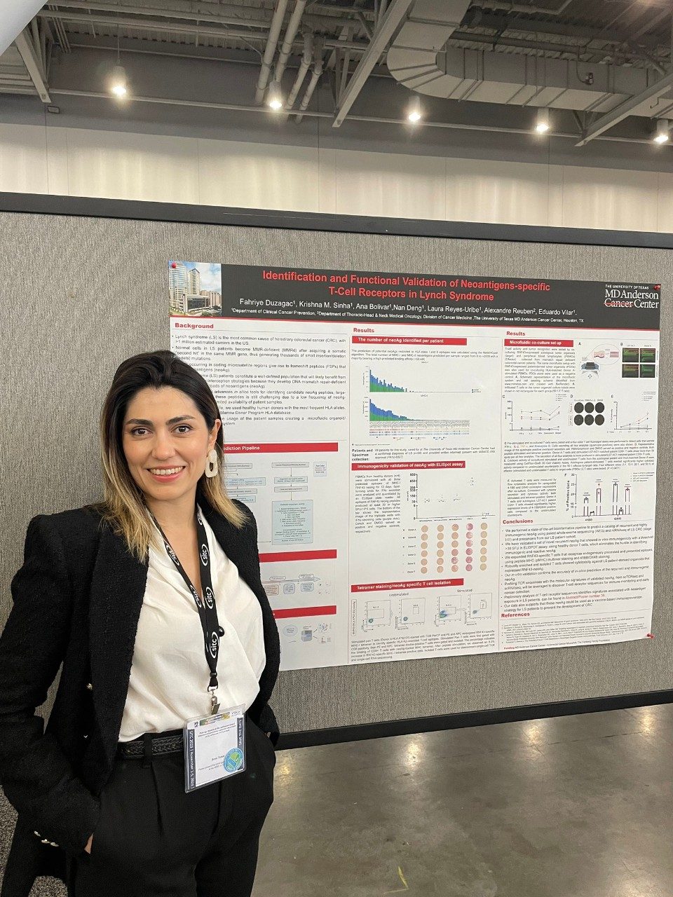 A woman stands in front of a poster