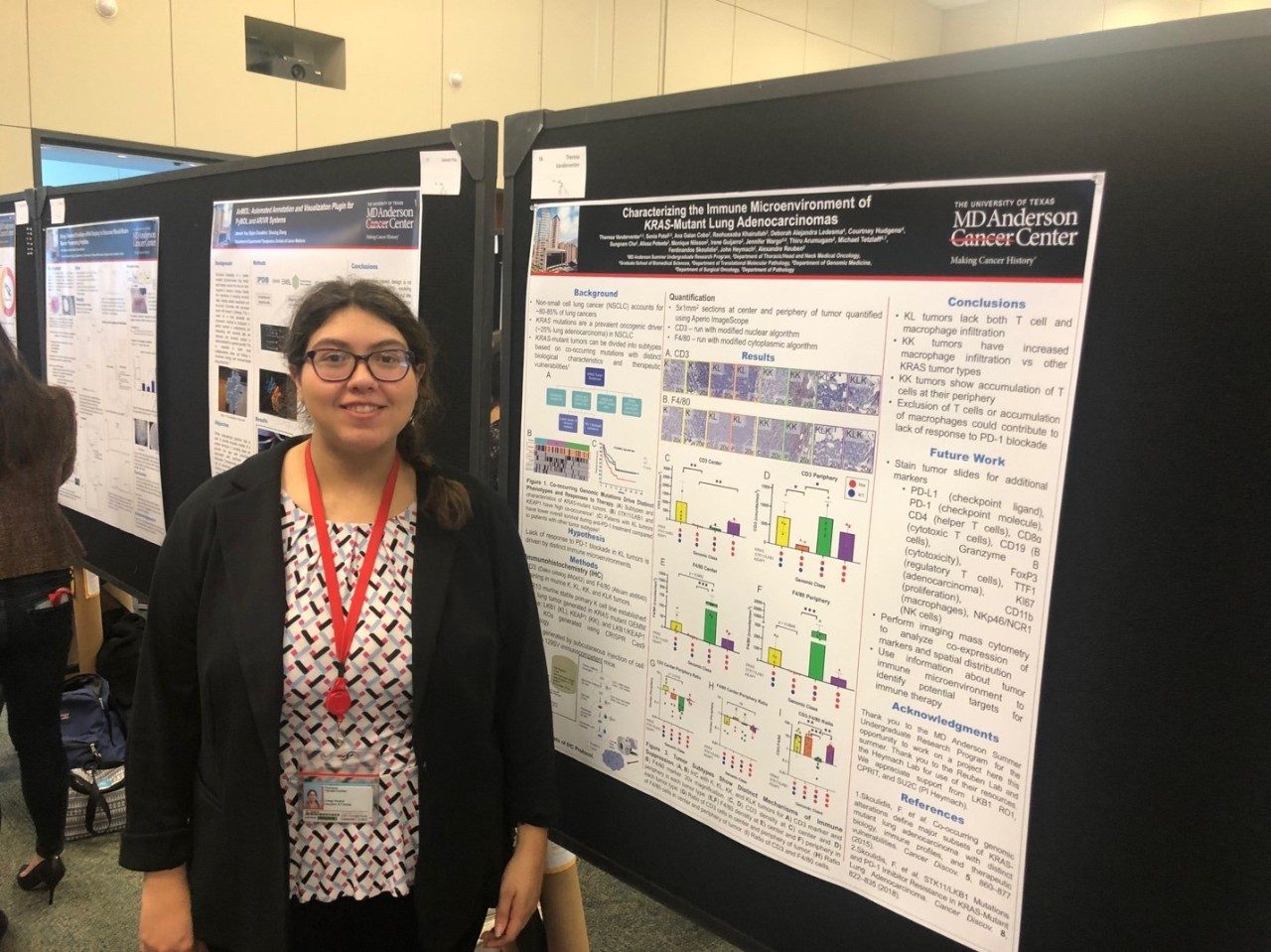 A woman stands in front of a poster