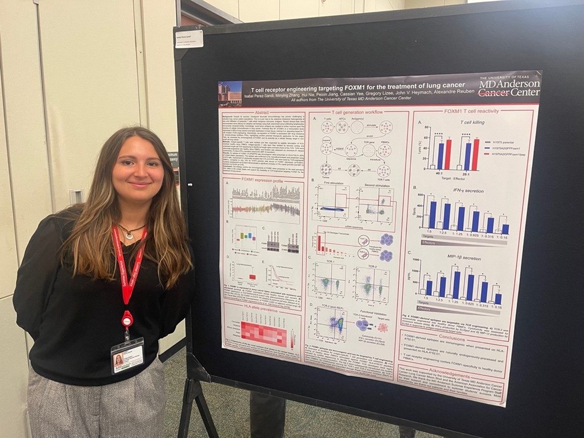 A woman stands in front of a poster