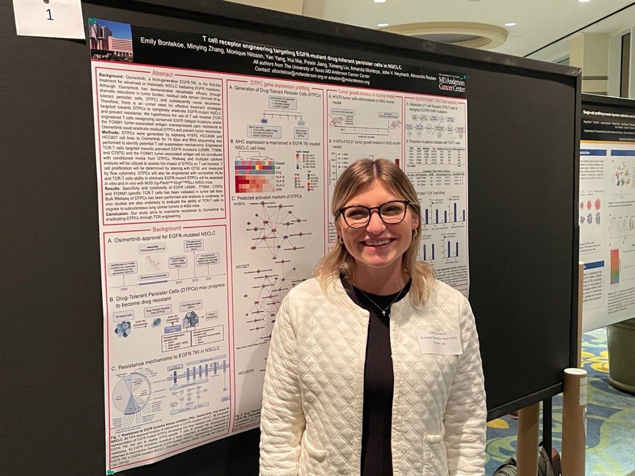 Emily posing next to her poster