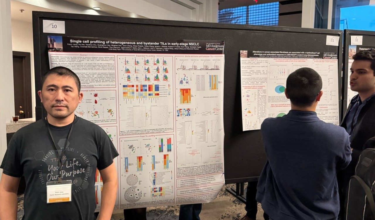 A man stands in front of a poster