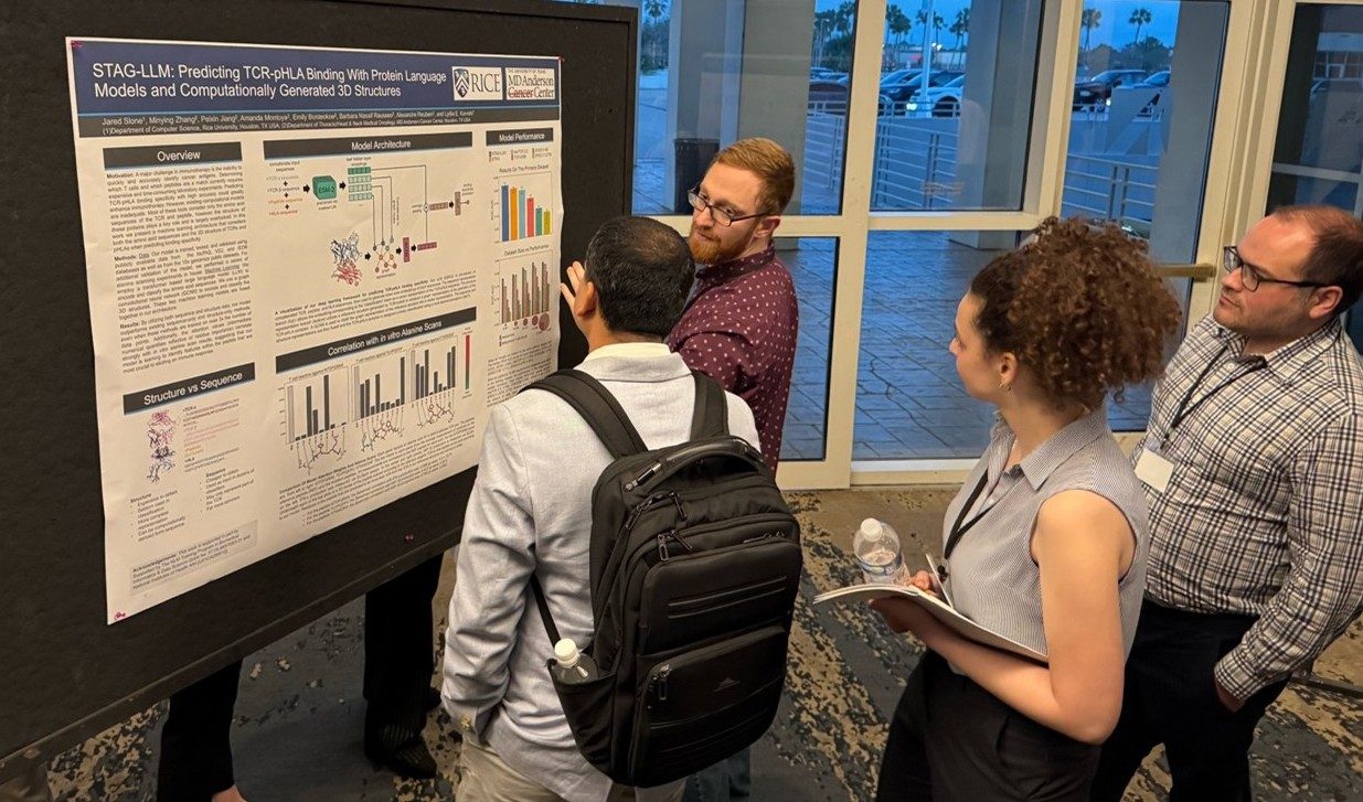 A man presents a poster to a group of onlookers