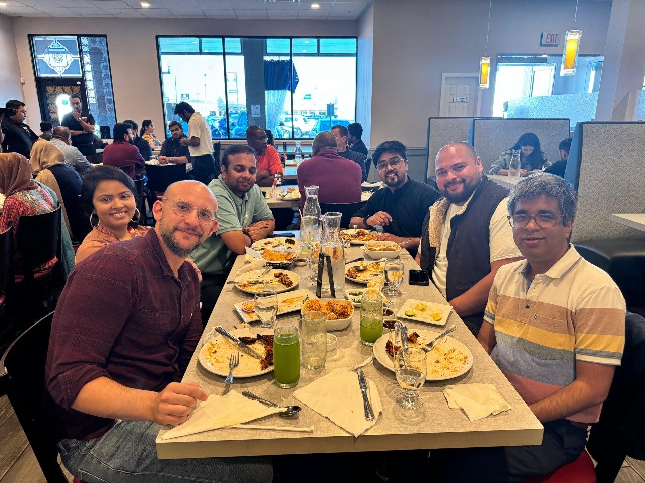 Six people seated around a rectangular table in a restaurant