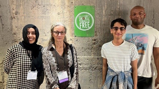 Four people with a Tobacco Free sign
