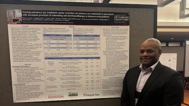 One man in front of a scientific poster