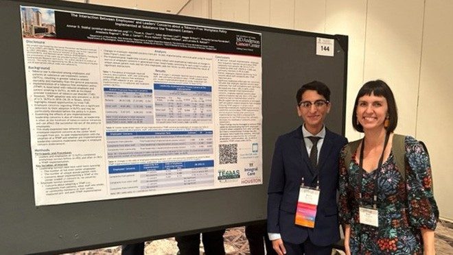 Two people in front of a scientific poster