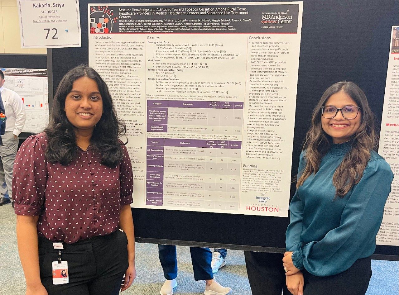 Two people posed in front of a scientific poster