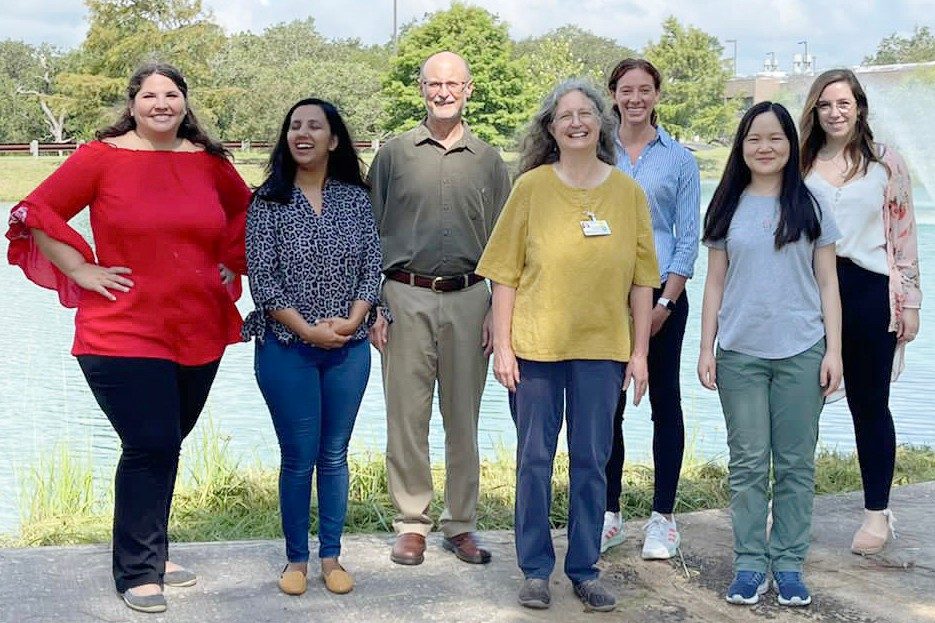 Group photo of the Wood lab taken near a small pond at Science Park