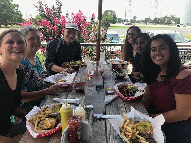 Group photo of the Wood Lab eating lunch, at a picnic table outside, at a local burger joint