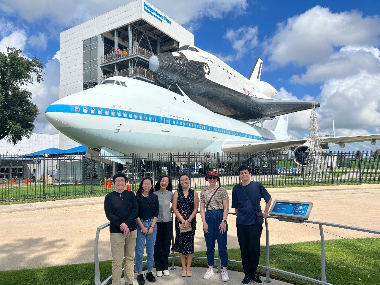 6 members of the Zhao Lab posing in front of a shuttle piggybacking on a plane at NASA's Independence Plaza