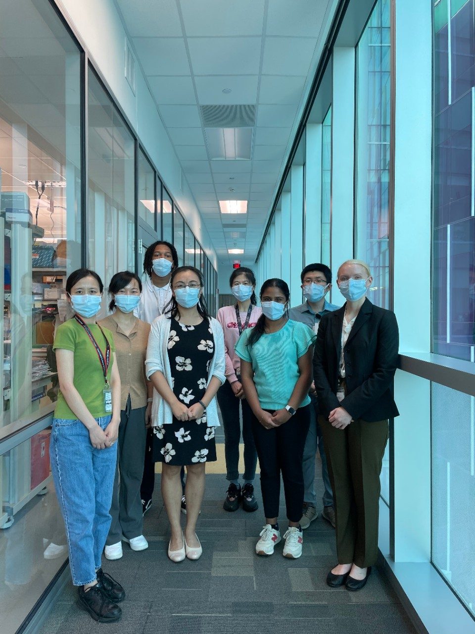 Group of people pose wearing masks
