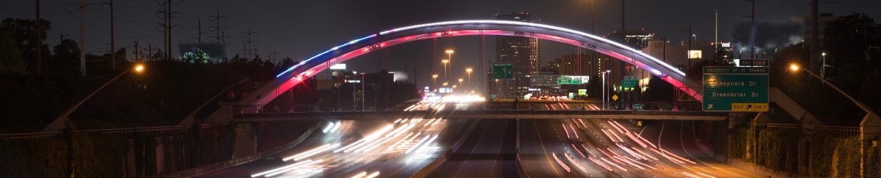 A bridge over a highway at night