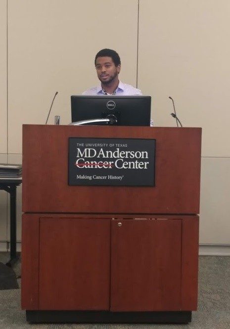 A man stands behind a lectern