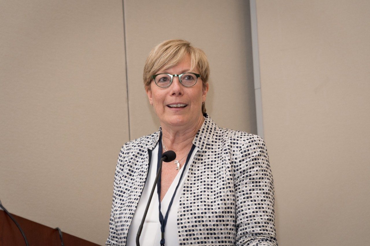 A woman stands behind a podium